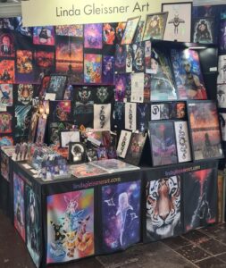 Messestand von Linda Gleissner Art mit farbenfrohen Fantasy-Prints, Tiermotiven und Anime-Postern
