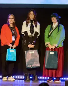 Siegesehrung des Art Contests: die drei Platzierten auf der Bühne der HiroCon im E-Werk Saarbrücken